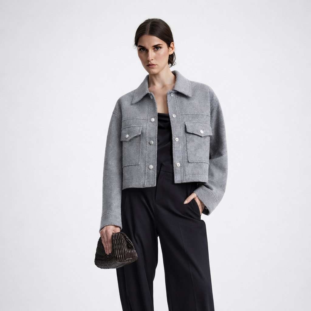 Woman wearing a gray jacket and black pants on a white background